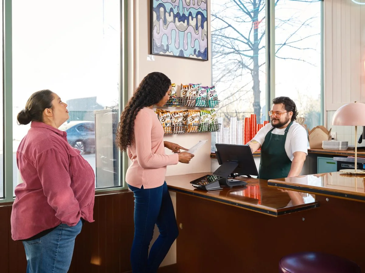 Restaurant employee serving customers at a counter